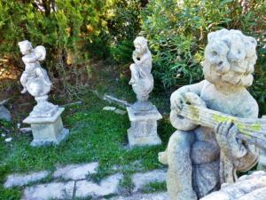  FOUR MUSICIANS PUTTI STATUE IN DRESSED STONE.